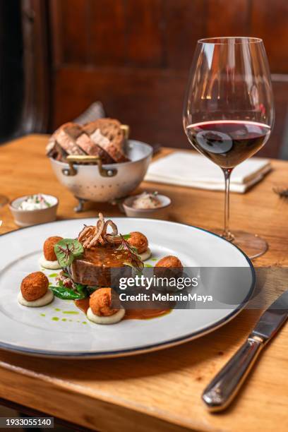 beef deer steak filet with fried sweetbread and gravy served with red wine at michelin star gourmet restaurant - sweet bread stock pictures, royalty-free photos & images