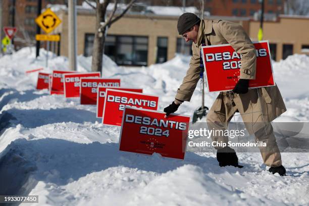 Volunteer plunges campaign signs for Republican Presidential Candidate, Florida Gov. Ron DeSantis into deep snow outside the Chrome Horse Saloon one...