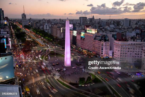 aerial view of city skyline and traffic illuminated at dusk - obelisco de buenos aires stockfoto's en -beelden