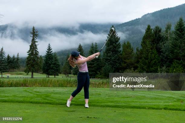 woman golfing on mountain golf course - golf swing female stock pictures, royalty-free photos & images