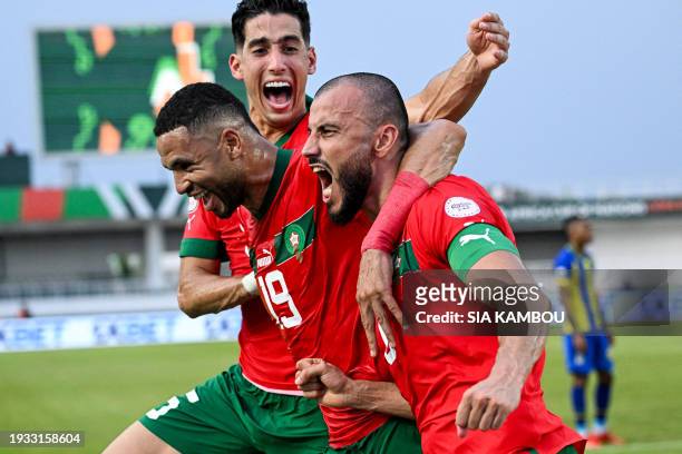 Morocco's defender Romain Saiss celebrates with Morocco's forward Youssef En-Nesyri and Morocco's defender Nayef Aguerd after scoring his team's...