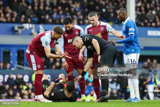 Referee, David Coote checks on Emiliano Martinez of Aston Villa after picking up an injury during the Premier League match between Everton FC and...