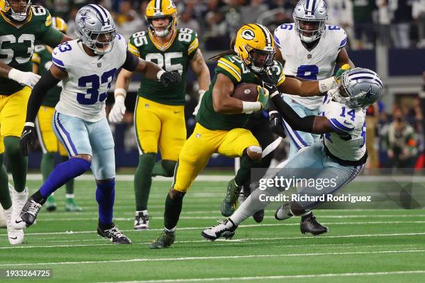 Aaron Jones of the Green Bay Packers is brought down by Markquese Bell of the Dallas Cowboys during the first quarter of the NFC Wild Card Playoff...