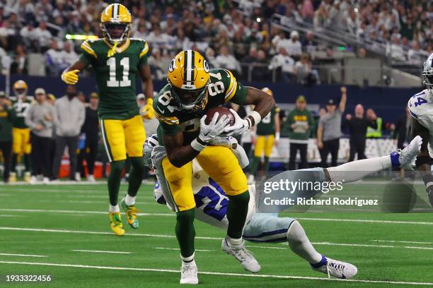 Romeo Doubs of the Green Bay Packers is brought down by Malik Hooker of the Dallas Cowboys during the first half of the NFC Wild Card Playoff game at...