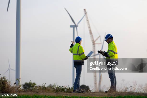 windmill engineer work in wind turbine farm with power crane installation wind turbine in the background - large construction site stock pictures, royalty-free photos & images