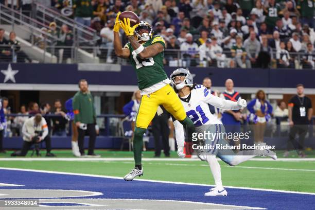 Dontayvion Wicks of the Green Bay Packers catches a pass for a touchdown in front of Stephon Gilmore of the Dallas Cowboys during the second quarter...