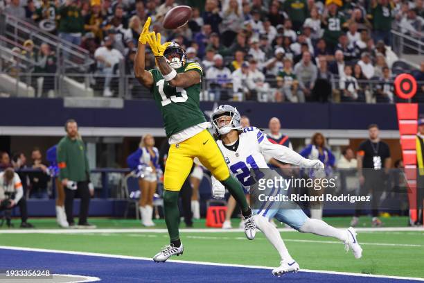 Dontayvion Wicks of the Green Bay Packers catches a pass for a touchdown in front of Stephon Gilmore of the Dallas Cowboys during the second quarter...
