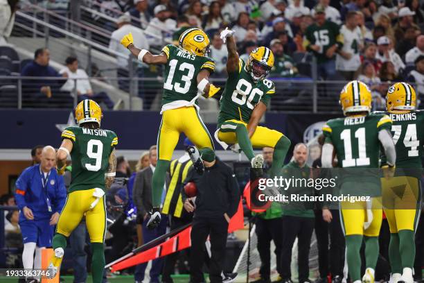 Dontayvion Wicks and Bo Melton of the Green Bay Packers celebrate a touchdown during the second quarter of the NFC Wild Card Playoff game against the...