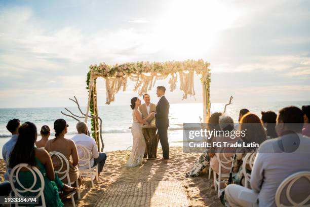sposo e sposa in cerimonia nuziale sulla spiaggia - invitato a un matrimonio foto e immagini stock