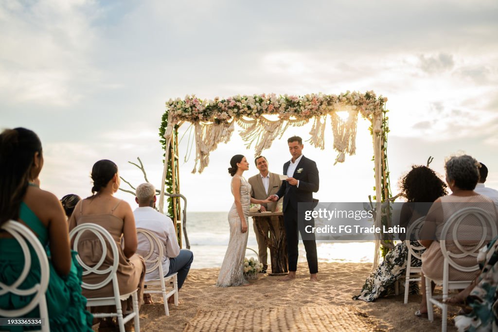 Groom speaking vows to his bride in the wedding ceremony on the beach