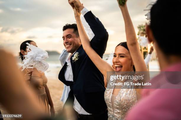 recién casados celebrando con sus invitados en ceremonia de boda en la playa - recién casados fotografías e imágenes de stock