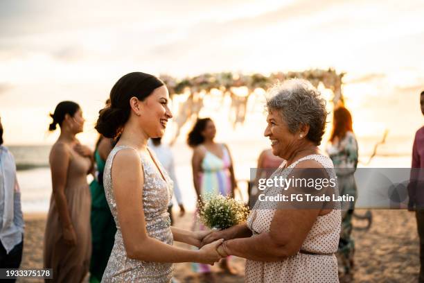 bride talking with her grandmother after wedding ceremony on the beach - beach wedding stock pictures, royalty-free photos & images
