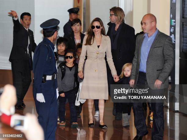 Accompanied by their children, US movie stars Brad Pitt and Angellina Jolie appear before photographers upon their arrival at Haneda Airport in Tokyo...