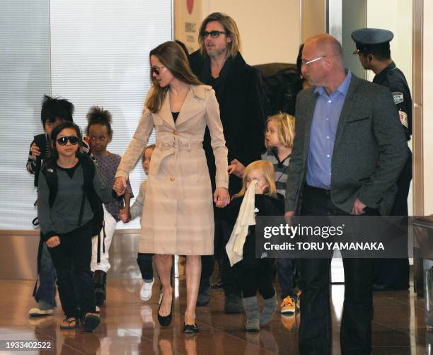 Accompanied by their children, US movie star Brad Pitt and Angellina Jolie appear before photographers upon their arrival at Haneda Airport in Tokyo...