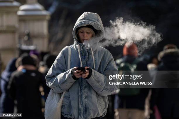 Person walks in freezing cold temperatures in New York City on January 17, 2024. Temperature highs in the city are expected to hit 25F .