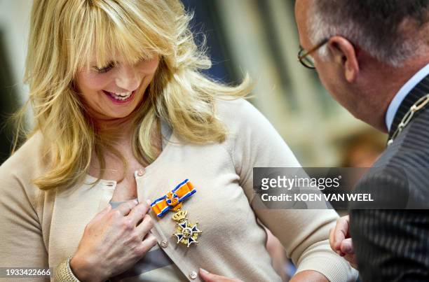 Dutch TV Hostess and actress Linda de Mol is promoted to Officer of the Order of Orange-Nassau as Deputy Mayor Fons Hertog of Huizen gives her the...