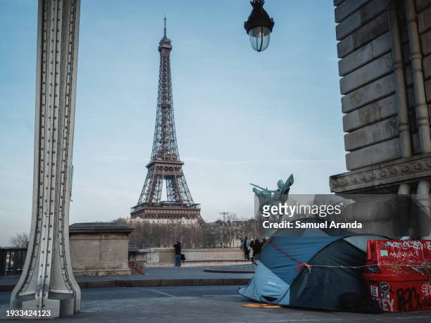 Tent of a migrant under the Bir Hakeim bridge, in the background can be seen the Eiffel Tower on January 16, 2024 in Paris, France. Insufficient...