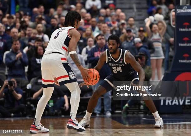 Georgetown Hoyas forward Supreme Cook on the defensive end while UConn Huskies guard Stephon Castle handles the ball during the game as the...