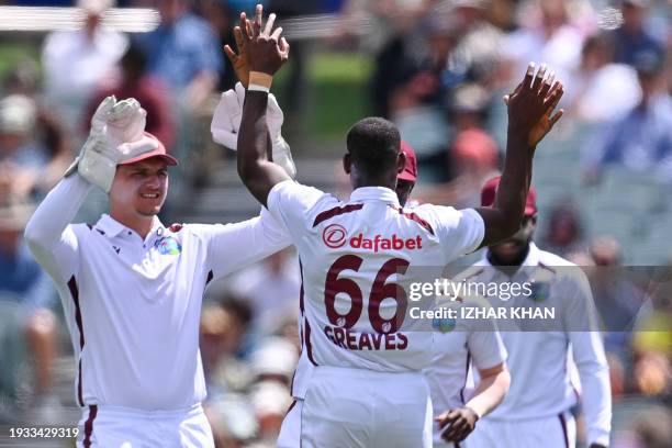 West Indies' Justin Greaves celebrates after taking wicket of Australia's Usman Khawaja during day two of the first cricket Test match between...