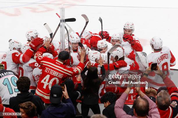 Teammates congratulate Dylan Larkin of the Detroit Red Wings after he scored an overtime goal to defeat the Florida Panthers 3-2 at the Amerant Bank...