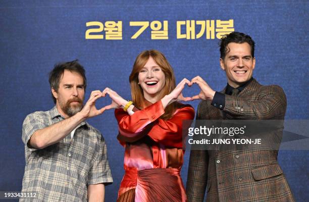Actors Sam Rockwell and Bryce Dallas Howard pose with British actor Henry Cavill for photos during a press conference to promote their film "Argylle"...