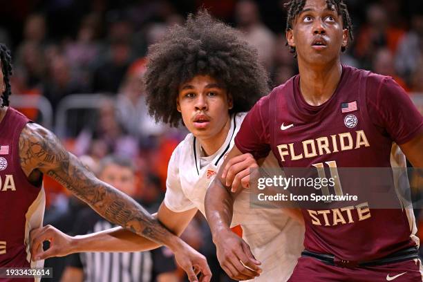 Miami guard Kyshawn George battles FSU forward Baba Miller for position on a rebound in the first half as the Miami Hurricanes faced the Florida...