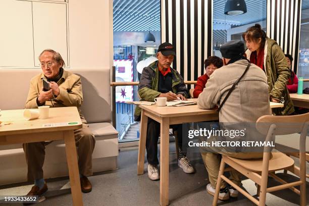 This photo taken on December 5, 2023 shows artist Li Shiqi drawing a portrait of another person at the Ikea restaurant, where elderly people gather...