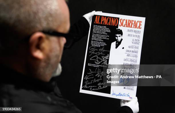 Propstore poster consultant Mark Hochman looks at an Al Pacino, Robert Loggia, Steven Bauer, Mark Margolis, Geno Silva, Mary Elizabeth Mastrantonio...