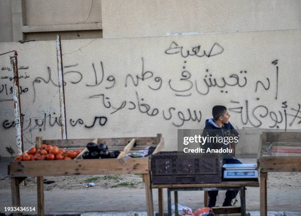 Palestinian boy who took refuge in Rafah sells the vegetables to make a living as daily life continues under harsh conditions in Rafah, Gaza on...