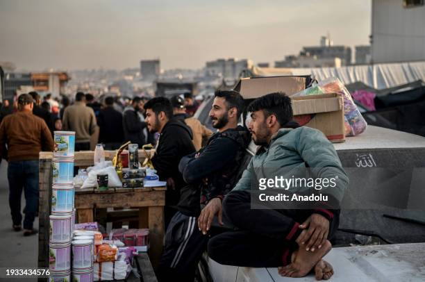 Palestinian people who took refuge in Rafah sell foodstuff to make a living as daily life continues under harsh conditions in Rafah, Gaza on January...