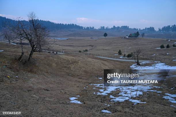 This photograph taken on January 17 shows ski slopes usually covered in snow at this time of the year at a ski station in Gulmarg, some 55 km from...