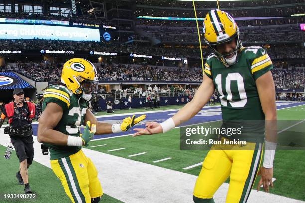 Aaron Jones of the Green Bay Packers celebrates a touchdown with Jordan Love following a second half touchdown against the Dallas Cowboys in the NFC...