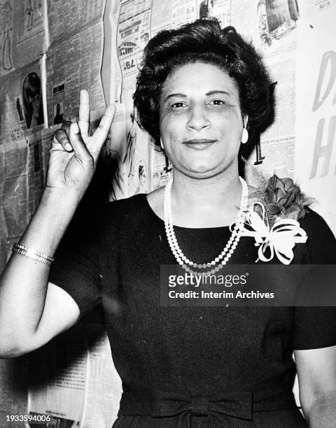 Portrait of African American jurist and politician Constance Baker Motley as she raises her right hand in a V sign, February 6, 1964. She was the...