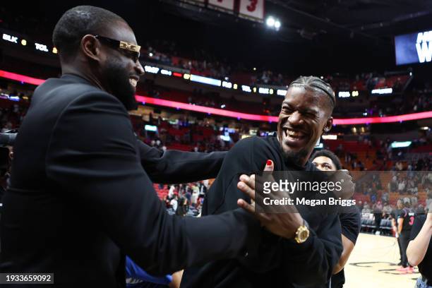 Former Miami Heat player Dwayne Wade and Jimmy Butler of the Heat embrace on the court after a game against the Charlotte Hornets at Kaseya Center on...