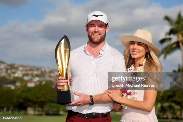 Grayson Murray of the United States and fiancee, Christiana, pose with the championship trophy after a victory on the first play-off hole during the...