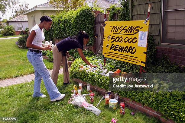 Narshala Powell and Lamonica Merkelson place stuffed animals outside Laci and Scott Peterson's home April 15, 2003 in Modesto, California....