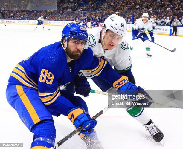 Alex Tuch of the Buffalo Sabres and Mark Friedman of the Vancouver Canucks battle along the boards during an NHL game on January 13, 2024 at KeyBank...