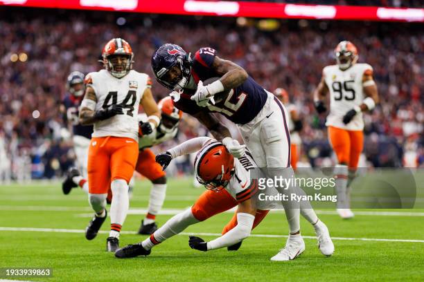Nico Collins of the Houston Texans dives into the end zone to score a touchdown during an AFC wild-card playoff football game against the Cleveland...