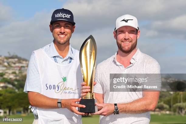 Grayson Murray of the United States and caddie, Jay Green, pose with the trophy after winning Sony Open in Hawaii at Waialae Country Club on January...