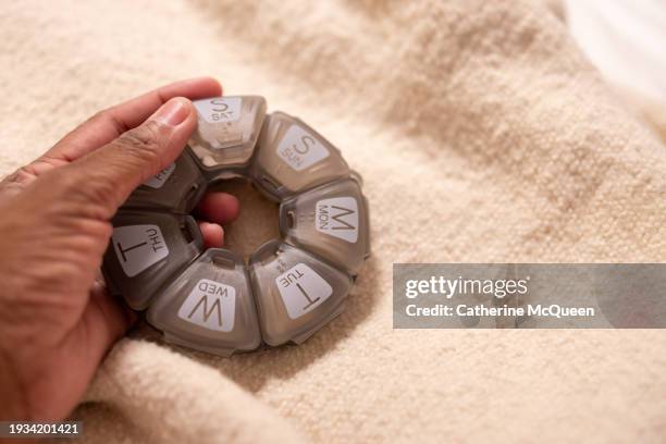 black woman holding plastic pill case organizer - autoimmune disease stock pictures, royalty-free photos & images