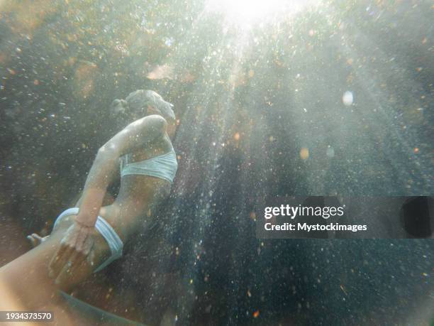 woman dives in tropical cenote, underwater shot - free diving stock pictures, royalty-free photos & images