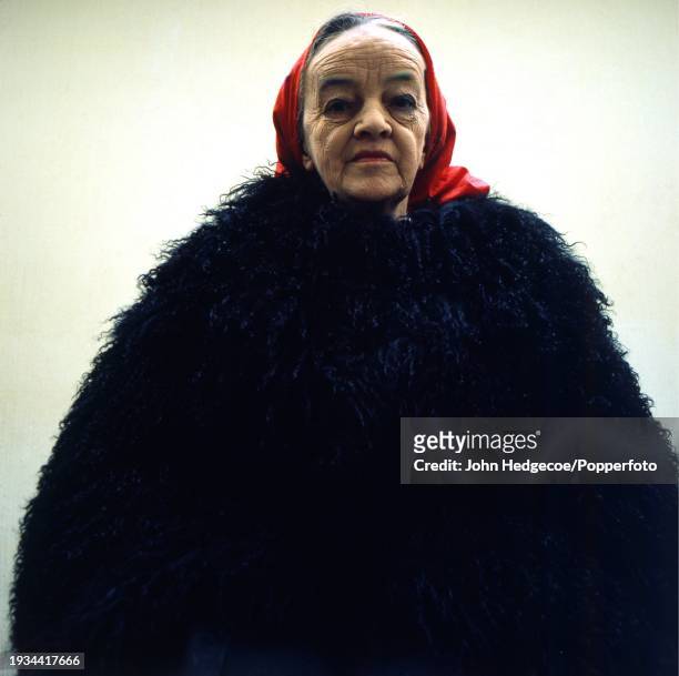 English artist and sculptor Barbara Hepworth posed wearing a thick wool coat and red headscarf at her studio workspace, Trwyn Studios in St Ives,...
