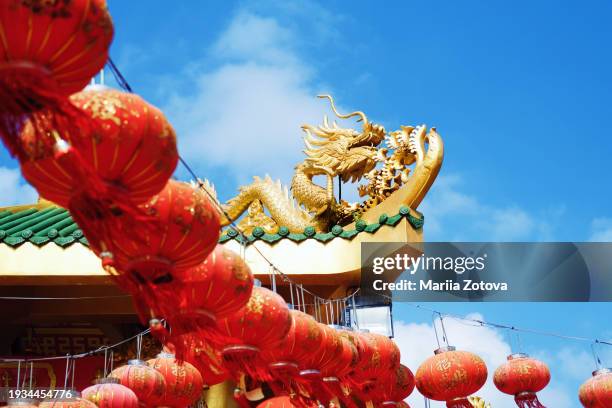 chinese symbol golden dragon on the roof of the temple surrounded by chinese lantern festival - the dragon stock pictures, royalty-free photos & images