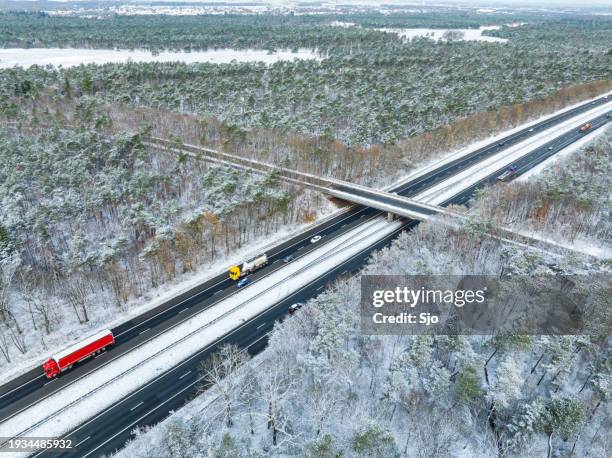 highway through a snowy forest landscape seen from above with a delivery truck truck - car underside stock pictures, royalty-free photos & images