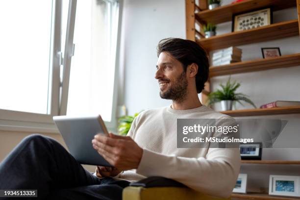 foto de ángulo bajo del hombre usando la tableta digital - un solo hombre fotografías e imágenes de stock