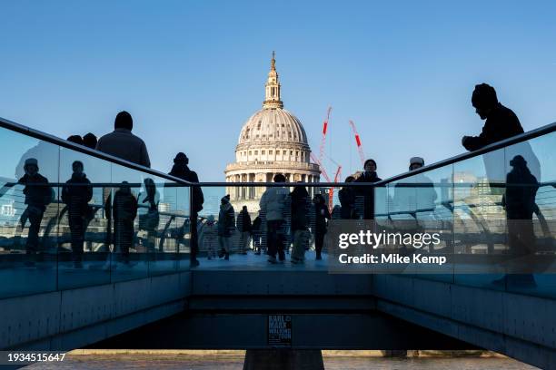 View of tourists and local people crossing the Millennium Bridge with St Paul's Cathedral rising in the background on 16th January 2024 in London,...