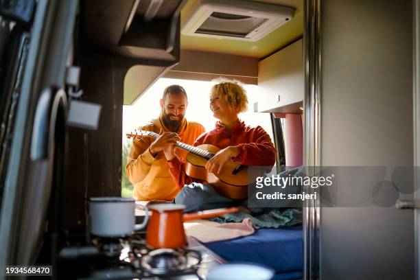 friends having fun while camping with a van - travel stock-fotos und bilder