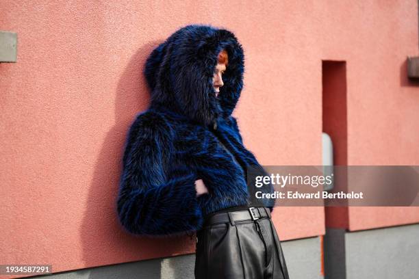 Pierre Painchaud wears a blue fluffy faux fur hoodie winter coat, a leather belt, black leather flared pants, outside K-WAY, during the Milan Fashion...