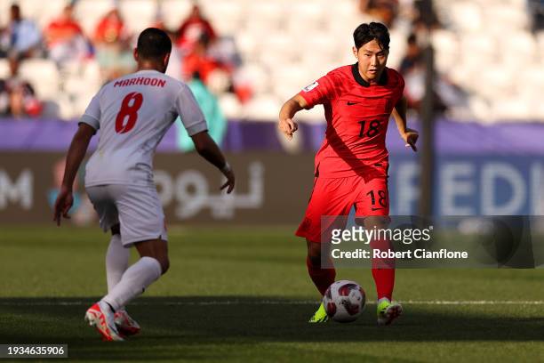 Lee Kang-In of South Korea and Mohamed Marhoon of Bahrain compete for the ball during the AFC Asian Cup Group E match between South Korea and Bahrain...