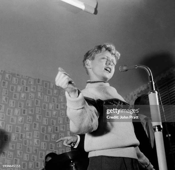 Danny Blond, aged 12, singing into a microphone with his eyes closed at a rehearsal studio in Soho, London, November 1956. Danny, from Maida Vale, is...